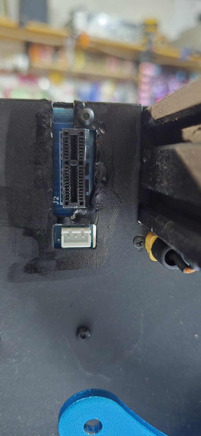 Vista exterior de la chapa de la X1 con el hueco agrandado y el conector J2 de la placa Z asomando