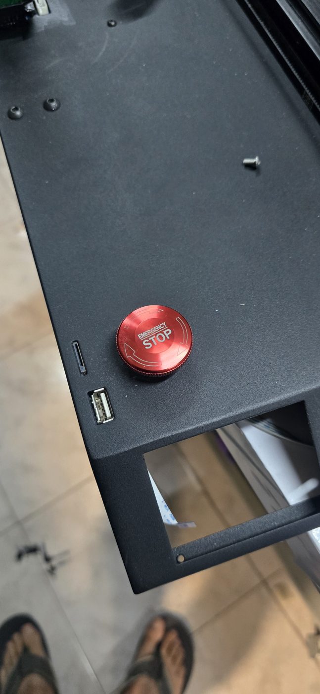 Seta de emergencia roja montada en la tapa de la base de la X1, junto al puerto USB