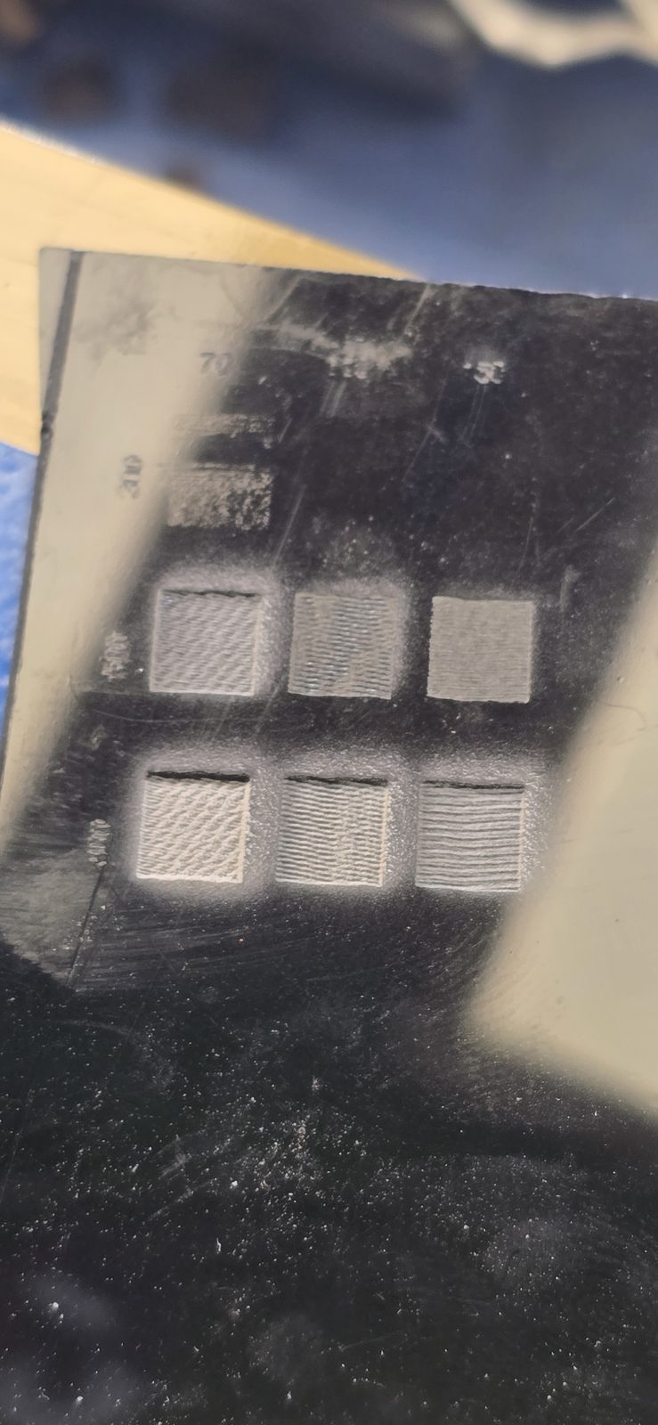 Metacrilato negro con la primera matriz de grabado: casillas de gris claro liso a gris hundido con rizo