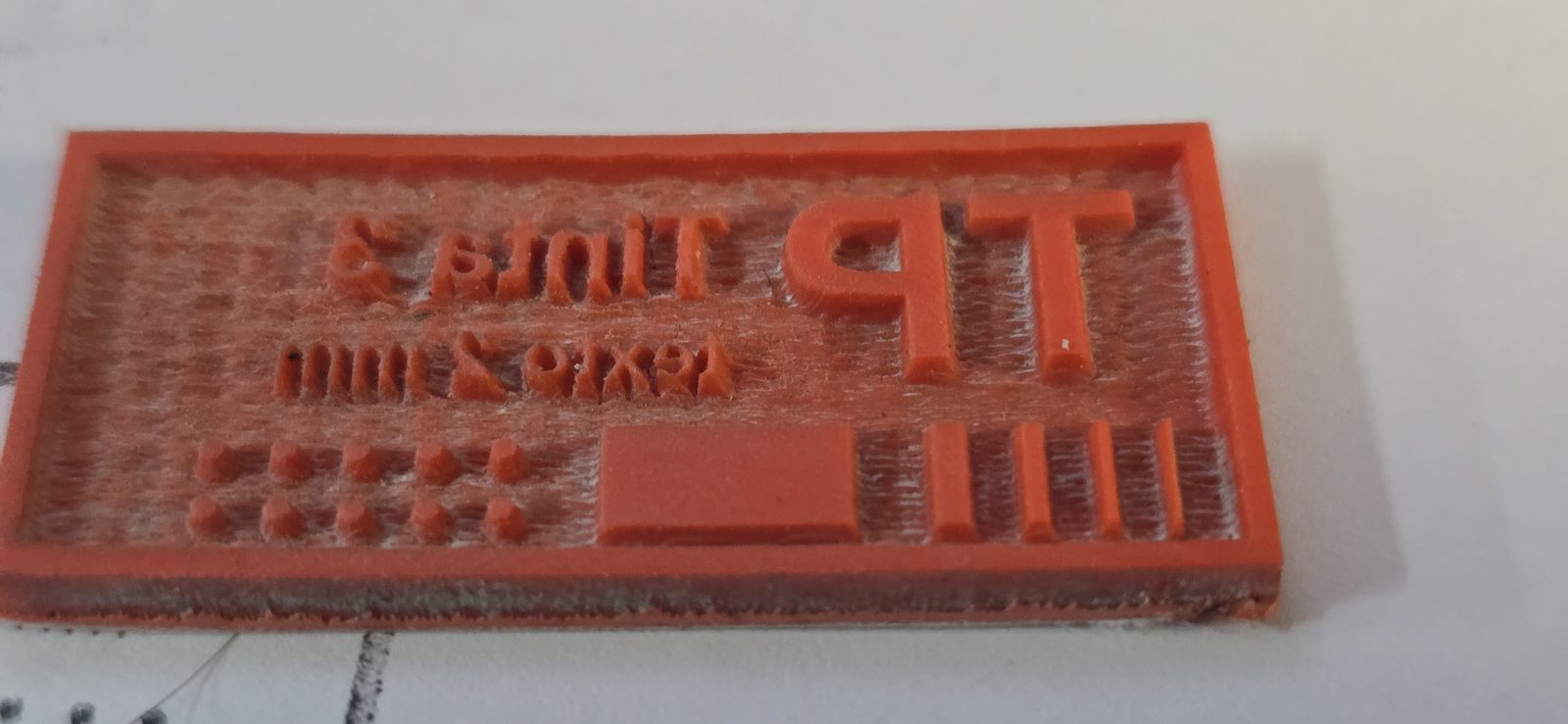 Sello de prueba en goma naranja con TP, texto de 3 y 2 mm, líneas finas, macizo y puntos, en espejo