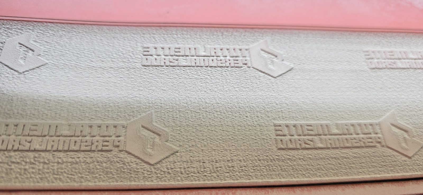 Detalle de los logos en relieve de la tira del rodillo, en espejo