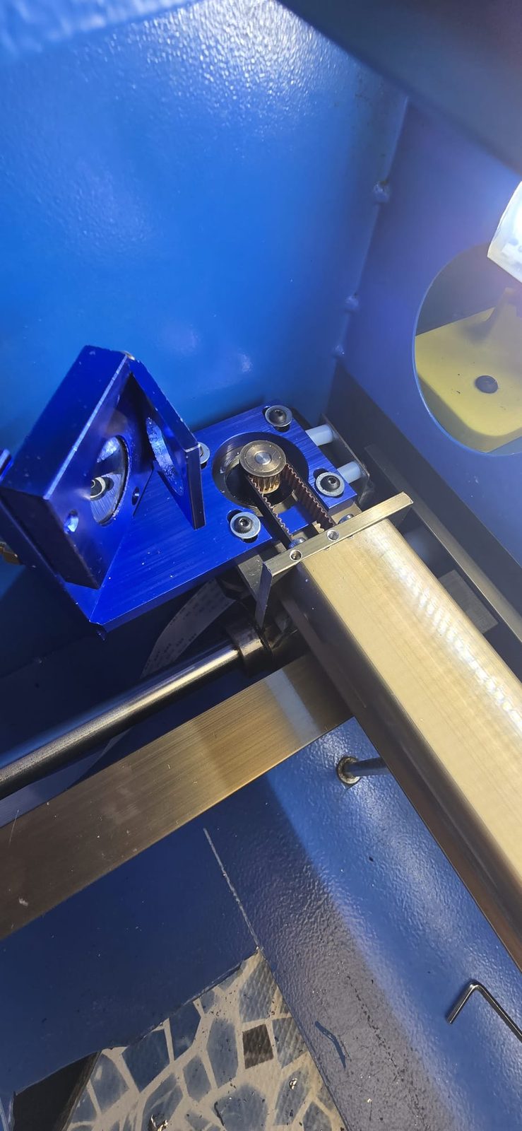 Soporte de espejo de aluminio azul en el extremo izquierdo del pórtico, junto a la polea y la correa de Y