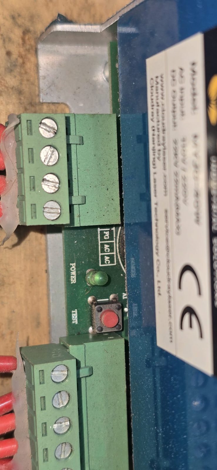 Detalle de la fuente: LED verde POWER y botón rojo TEST junto a los bornes